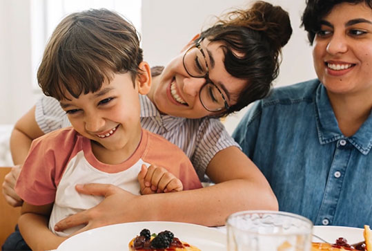 Family cuddling at the breakfast table